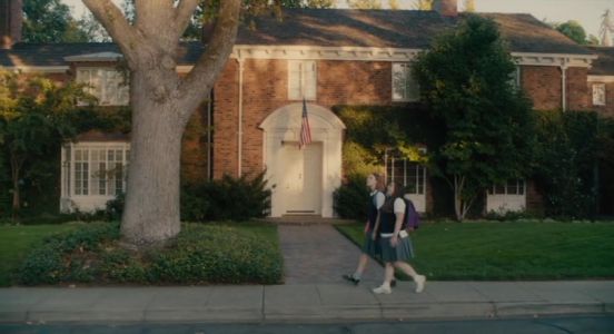 Lady Bird and Julie walk through an affluent neighborhood.